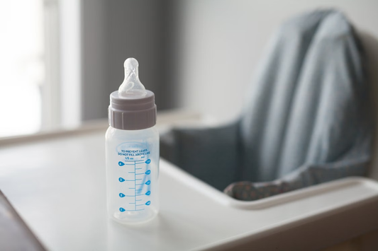 A baby bottle placed on a high chair